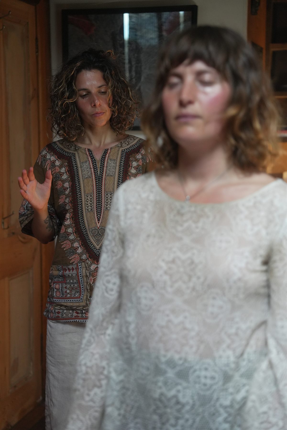 Vanessa working with her hands raised behind a client during an energy healing session