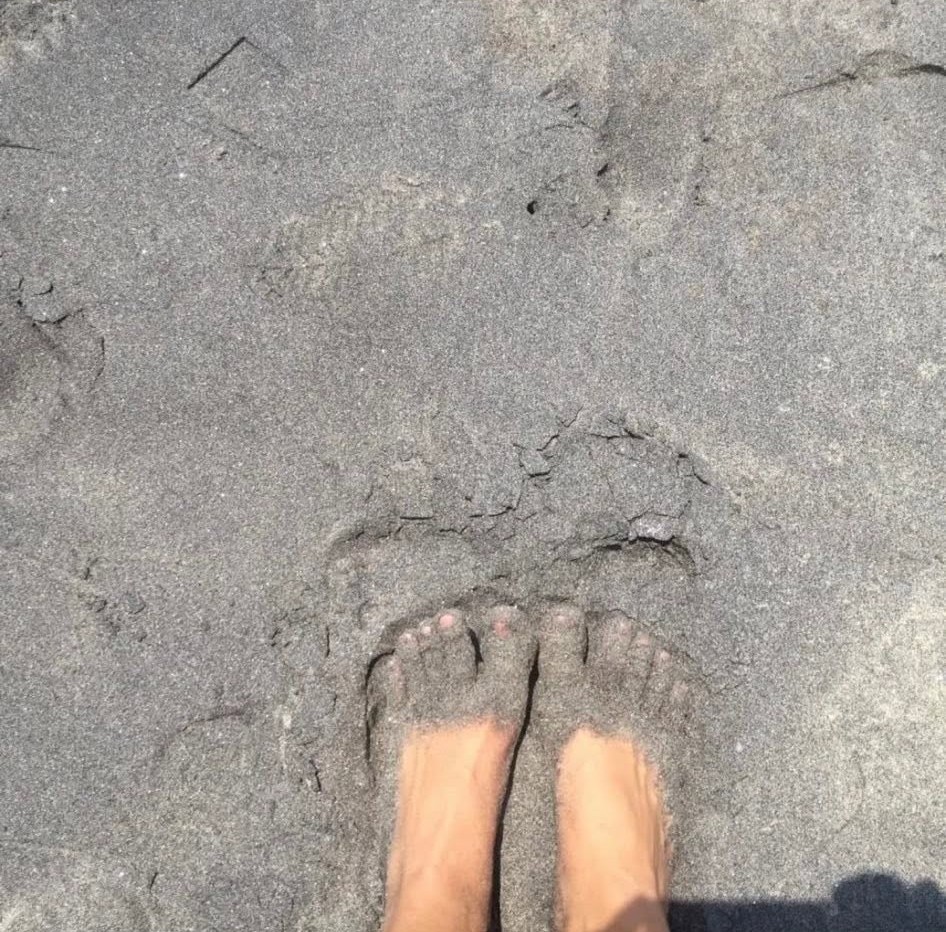 Bare feet resting in soft beach sand