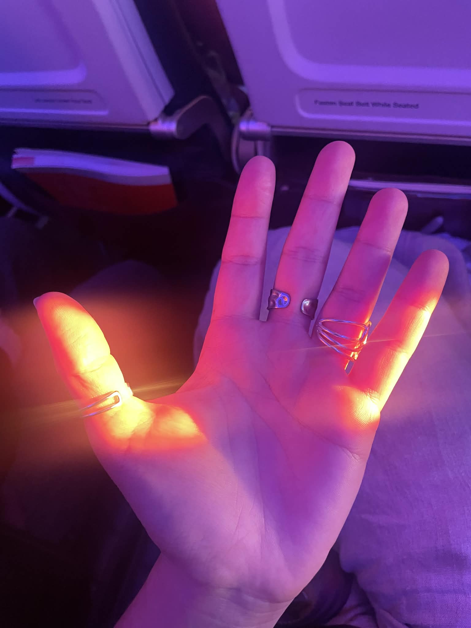 Vanessa's open hand, rings catching the light